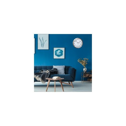 Ein dunkelblauer Sofa mit Kissen und Decke vor blauer Wand mit Uhren und Bildern.