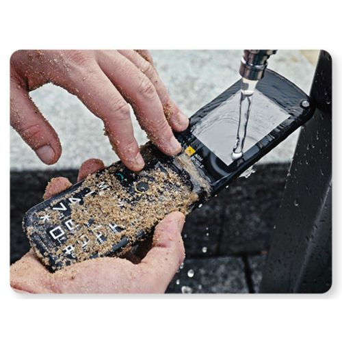 Mani sciacquano un telefono a conchiglia sabbioso sotto l'acqua corrente. Il telefono è sporco.