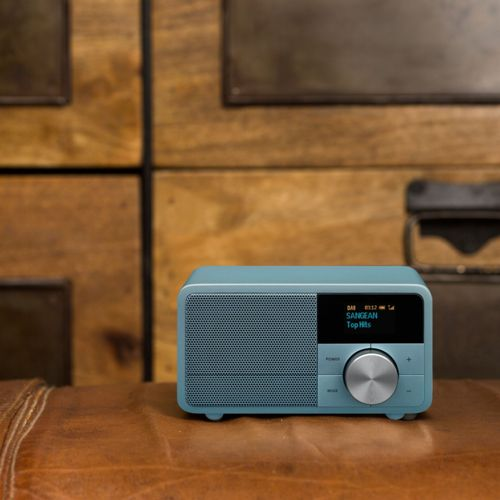 Una radio Sangean blu con quadrante argentato è su pelle.