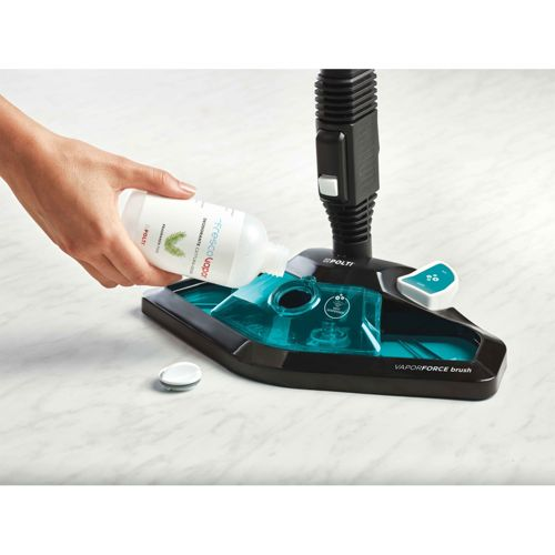 Una mano versa liquido da una bottiglia in una testa di mocio a vapore nero e turchese su pavimento in marmo.