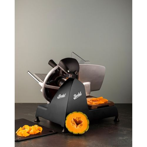 Affettatrice Berkel nera con zucca dimezzata accanto.