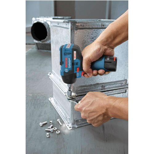 Een hand houdt een blauwe Bosch slagschroevendraaier vast om een metalen doos te bevestigen.