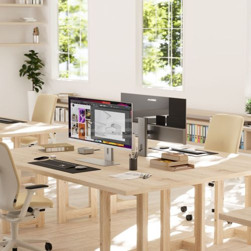 Un ufficio con scrivanie in legno, computer, sedie e scaffali, ben illuminato.