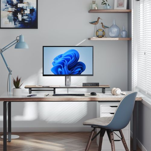 Configuration de bureau moderne avec ordinateur, clavier, souris, casque et lampe bleue.