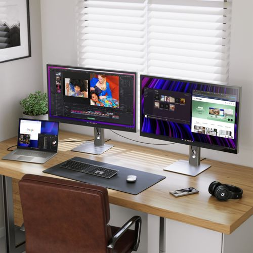 Un bureau avec deux moniteurs, un ordinateur portable, un clavier, une souris et des écouteurs.
