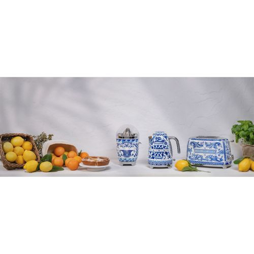 Obst und Küchengeräte mit blau-weißem Dekor vor hellem Hintergrund.