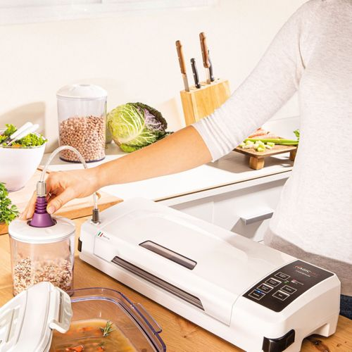 A person uses a vacuum sealer on a canister of grains in a kitchen.