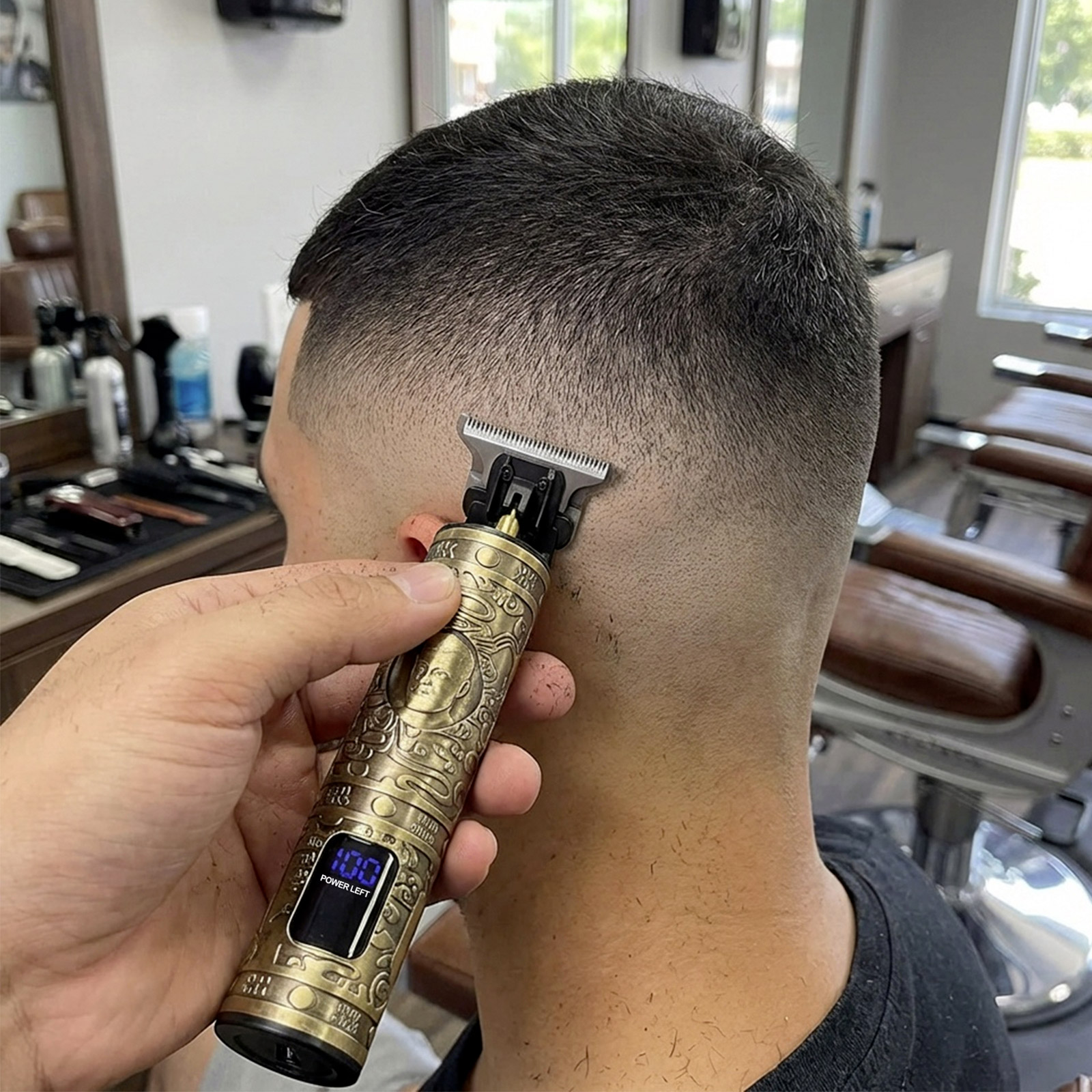 Ein Mann bekommt die Haare mit einem goldenen Trimmer geschnitten. 100% Akku angezeigt.