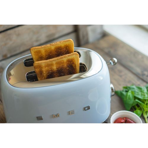 Ein heller Toaster mit zwei Toastscheiben, daneben ein Schälchen mit Oliven.