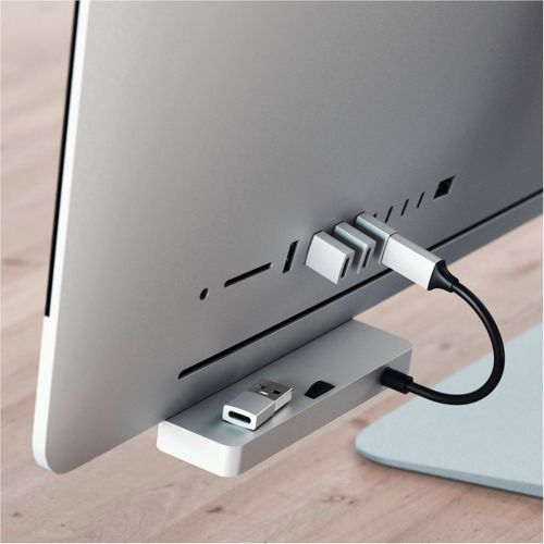 Un hub per computer argentato con chiavette USB e cavi collegati a un monitor.