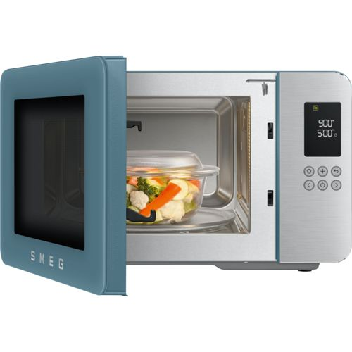 Açık kapılı mavi Smeg mikrodalga fırın, içinde sebzeli cam kase gösteriyor.