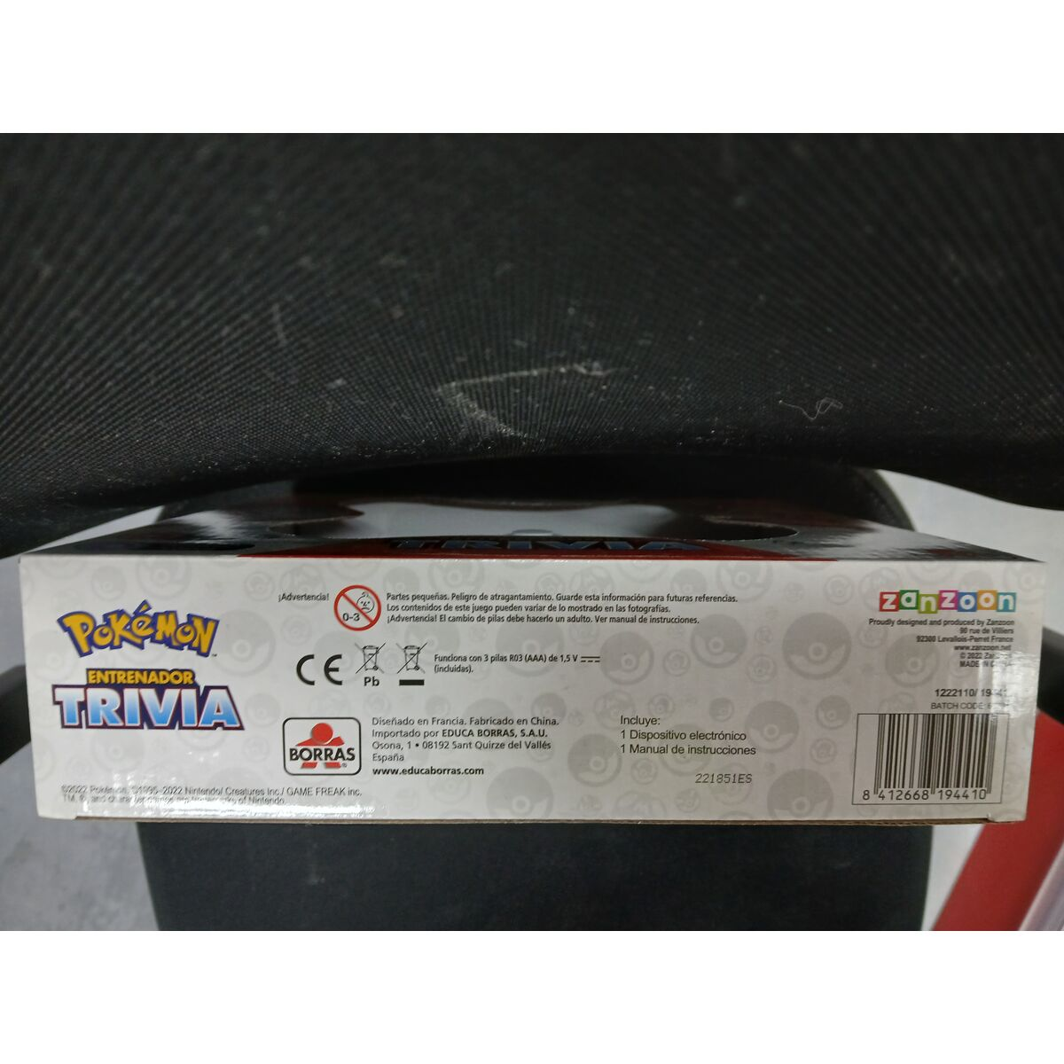 Caja del juego Pokémon Entrenador Trivia con advertencias e información.