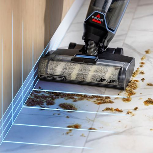 Un pulitore per pavimenti Bissell con spazzola pulisce un pavimento in marmo sporco.