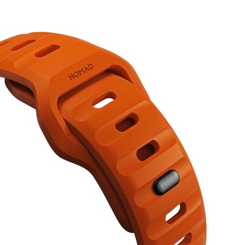 Una correa de reloj naranja con la palabra "NOMAD" y ranuras de ventilación.