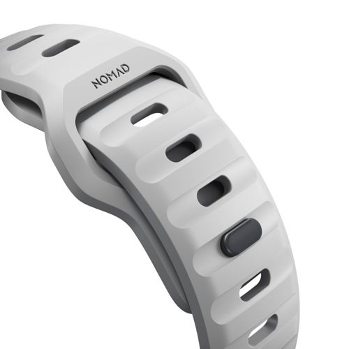 Un bracelet de montre gris avec des fentes ovales et le mot NOMAD.