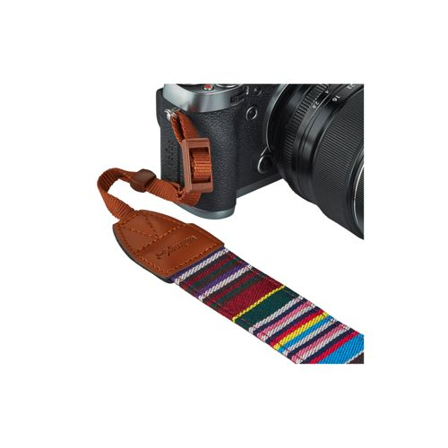 Una fotocamera con un cinturino colorato in tessuto e pelle.
