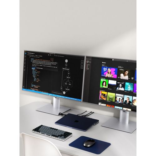 Zwei Monitore auf einem Schreibtisch mit Laptop, Tastatur und Maus.
