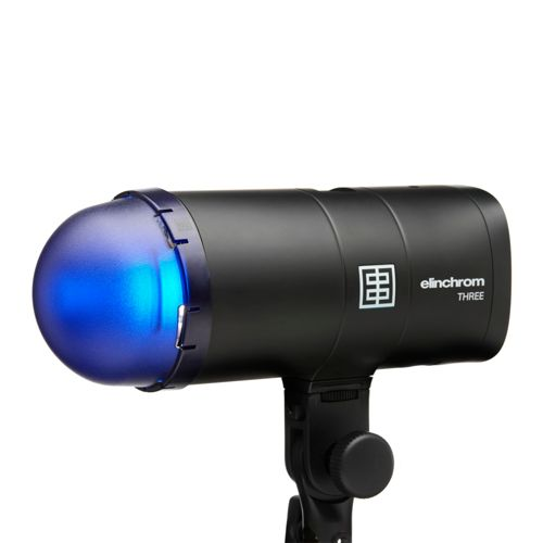 Une tête de flash Elinchrom noire avec un dôme bleu émet de la lumière.