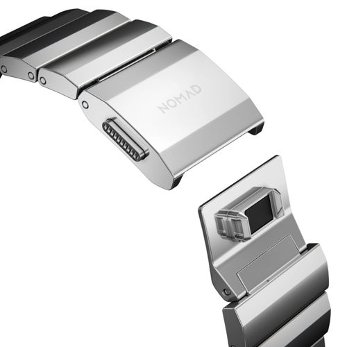 Una correa de reloj plateada con logo NOMAD, mostrada abierta.