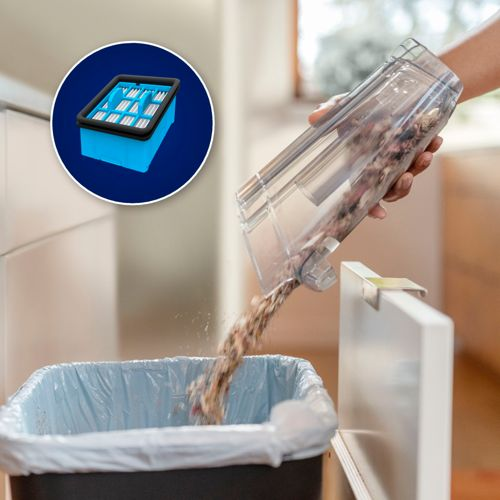 Un filtro per aspirapolvere blu e un contenitore pieno di sporco svuotato in un cestino.
