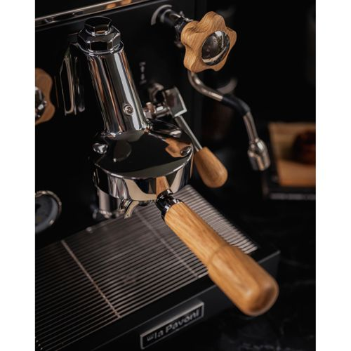 Una macchina per espresso con manici in legno e parti in metallo lucidato.