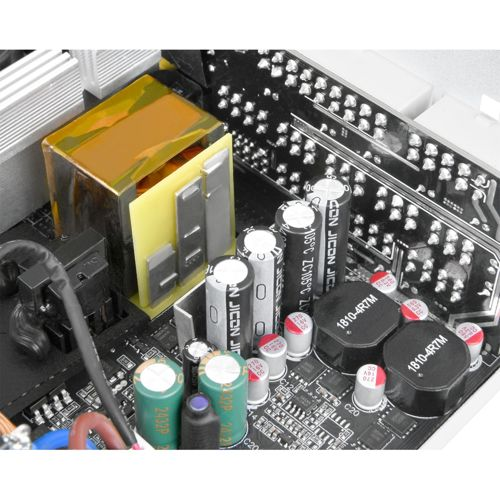Scheda elettronica con condensatori, induttori e un trasformatore.