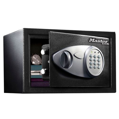 Una caja fuerte negra Master Lock está abierta, revelando libros y un reloj dentro. Teclado digital en la puerta.