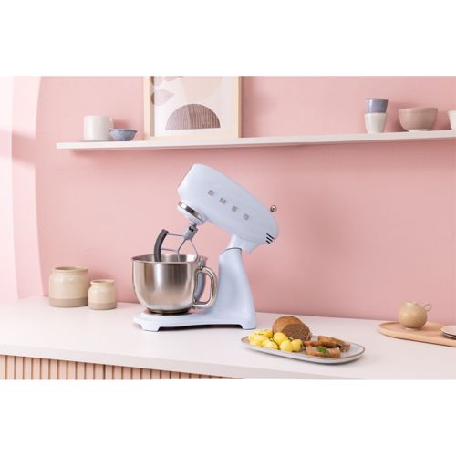 Un robot de cocina azul claro con bol de acero inoxidable sobre una encimera.