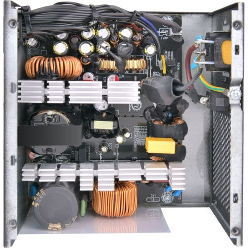 Vista interna di un alimentatore con bobine di rame, condensatori e dissipatori.