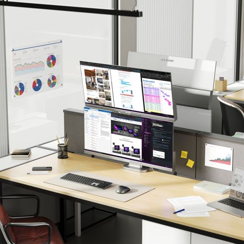 Ein moderner Büroschreibtisch mit mehreren Monitoren, die Diagramme, Grafiken und Code anzeigen.