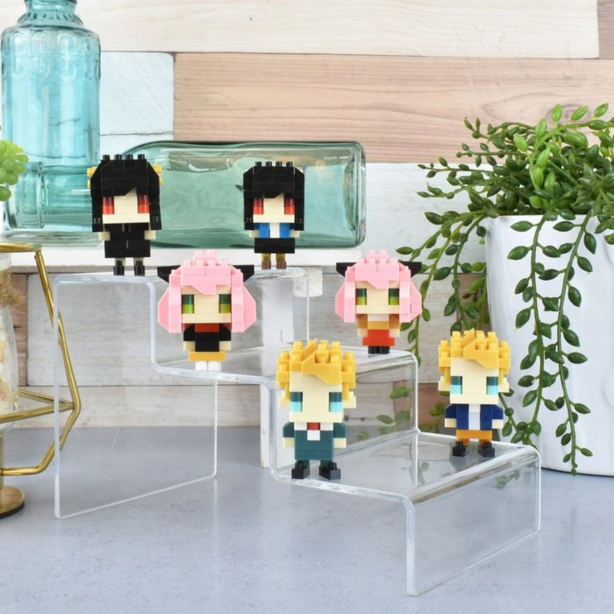 Sei figure pixel art su gradini trasparenti, con piante e bottiglie sullo sfondo.