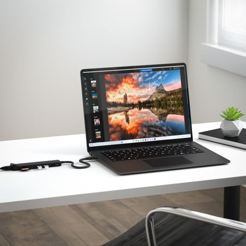 Ein schwarzer Laptop mit einem Bild eines Bergsees bei Sonnenuntergang auf dem Bildschirm.