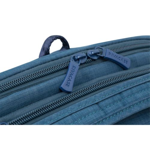 Primo piano di uno zaino blu con cerniere e logo RIVACASE.