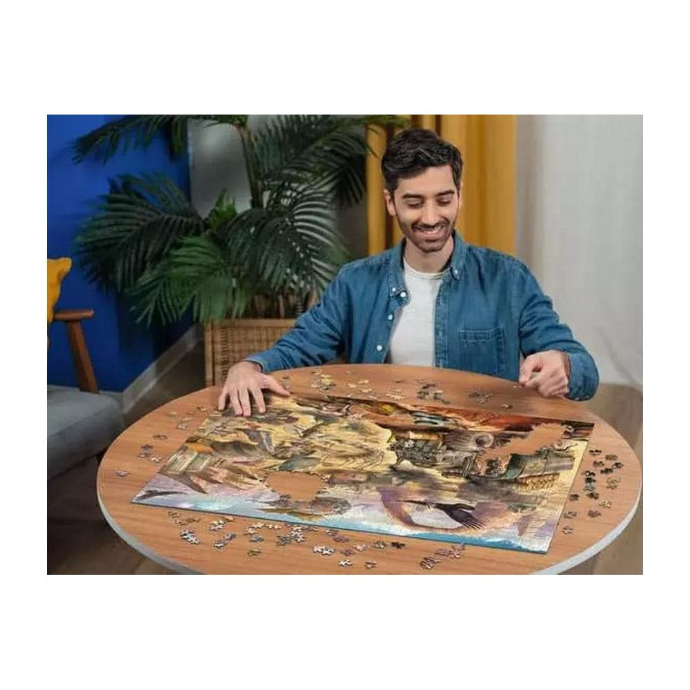 Un uomo siede a un tavolo rotondo assemblando un puzzle. Lo sfondo è sfocato.