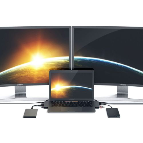 Laptop collegato a monitor esterni, hard disk e smartphone.