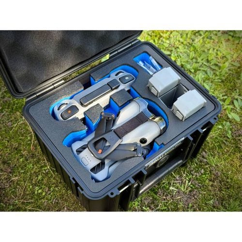 Un kit drone grigio con due batterie in una custodia protettiva nera con rivestimento blu.