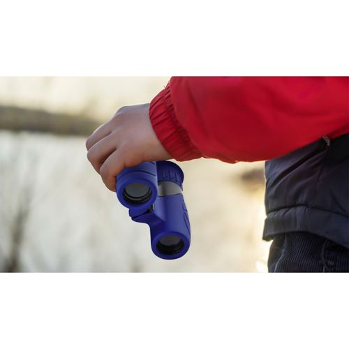 Un bambino tiene un binocolo blu, indossa una giacca rossa e pantaloni.