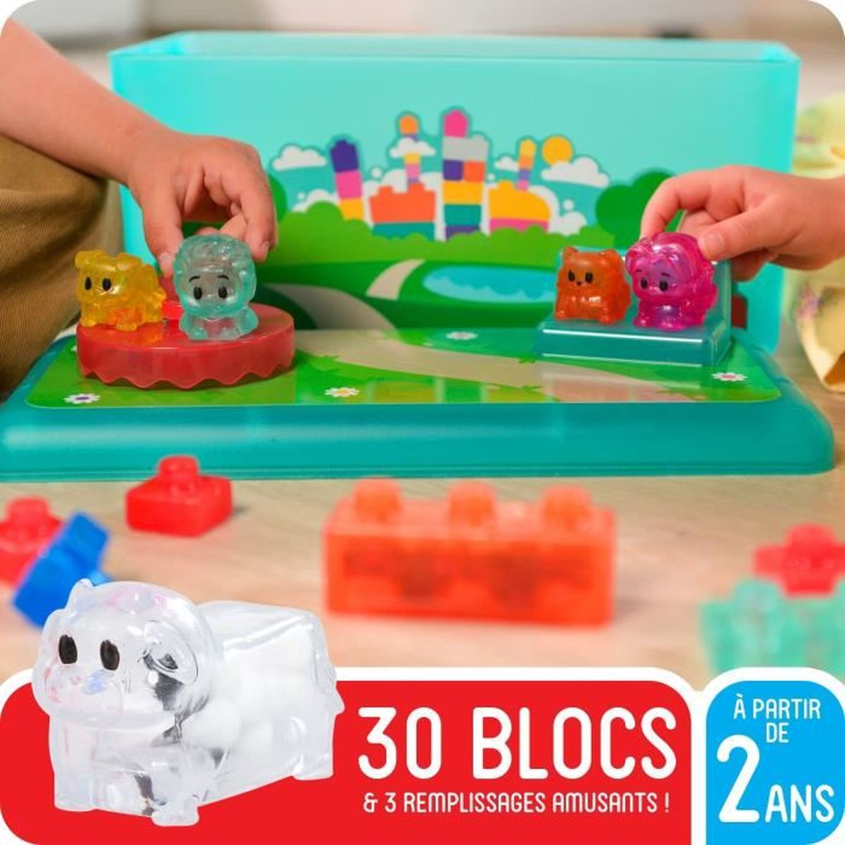 Bambini giocano con animali traslucidi e blocchi da costruzione su un tappetino colorato.