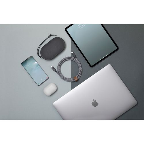Un laptop, tablet, smartphone, auricolari e cavo di ricarica su sfondo grigio.