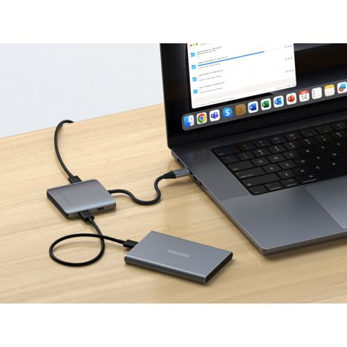 Grauer Laptop mit angeschlossenem USB-C-Hub und externer Festplatte.