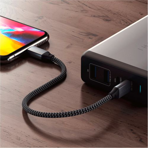 Uno smartphone è collegato a un power bank con un cavo intrecciato.