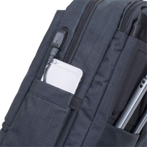 Grijze rugzak met telefoon en USB-poort. Laptop ernaast.