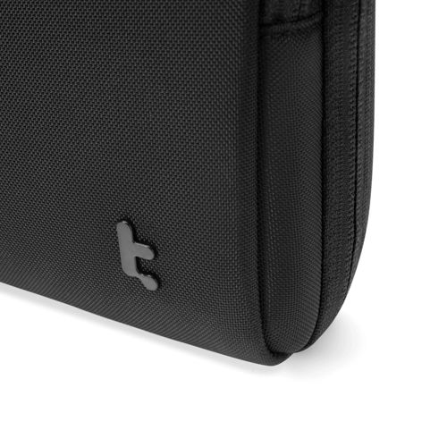 Eine schwarze Tasche mit einem kleinen Logo auf der Vorderseite.