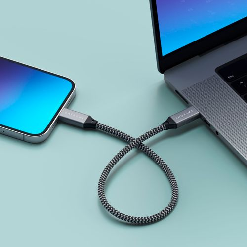Un cavo intrecciato collega uno smartphone a un laptop. Entrambi i dispositivi sono grigi.