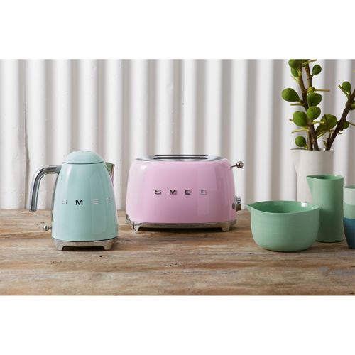 Nane yeşili SMEG su ısıtıcısı ve pembe SMEG ekmek kızartma makinesi yan yana duruyor.
