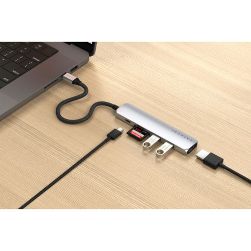Un hub USB-C argento collegato a un laptop, con scheda SD e unità USB.