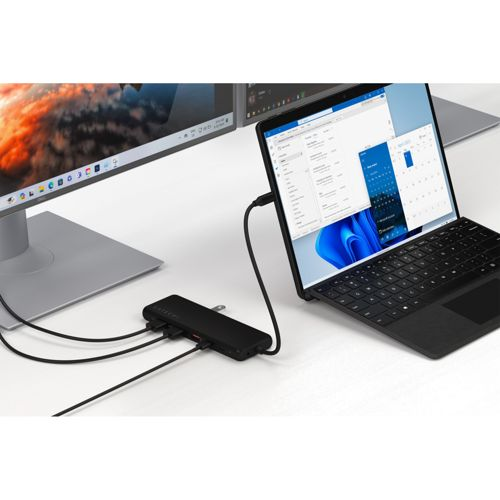 Schwarze USB-C-Dockingstation verbindet Laptop und Monitor, zeigt Windows 11.