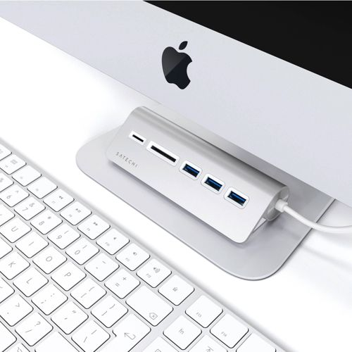 Ein silberner Satechi-Hub mit Anschlüssen vor einem iMac und einer Tastatur.
