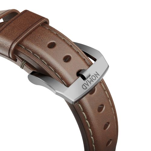Braunes Lederarmband einer Uhr mit Metallschnalle mit der Aufschrift "NOMAD".