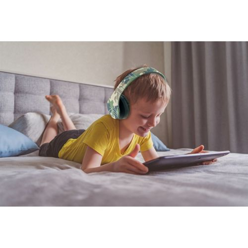 Un ragazzo con cuffie mimetiche giace sul letto usando un tablet.